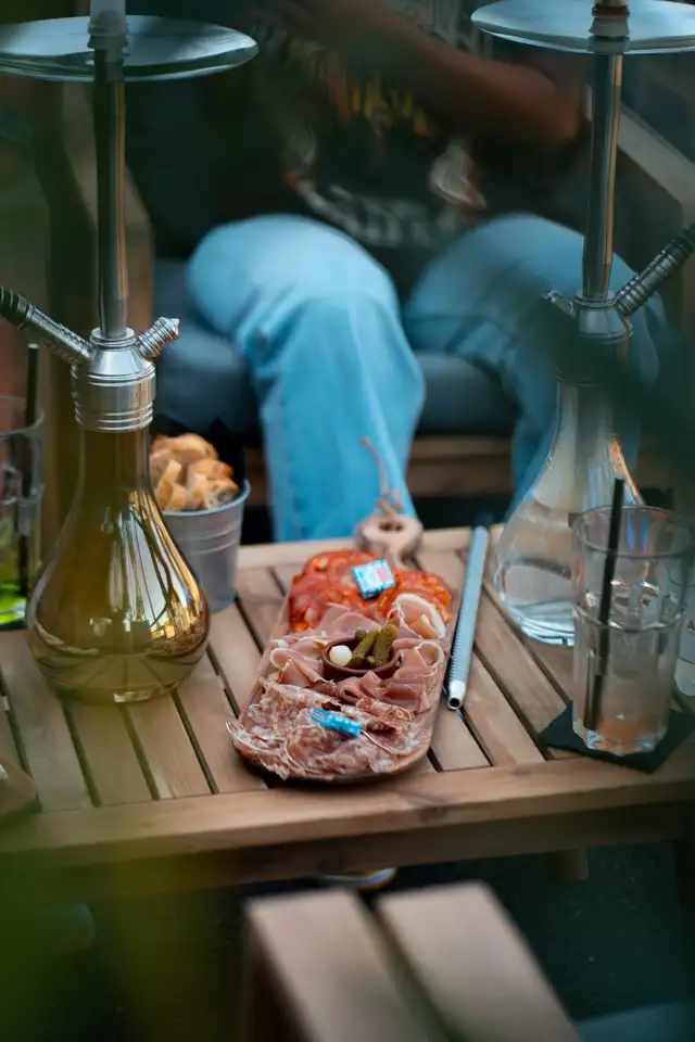 Table avec narguilé et planche à partager, clients installés sur la banquette