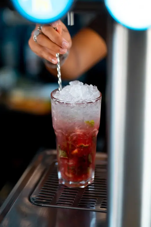 Un barman prépare un cocktail derrière le comptoir