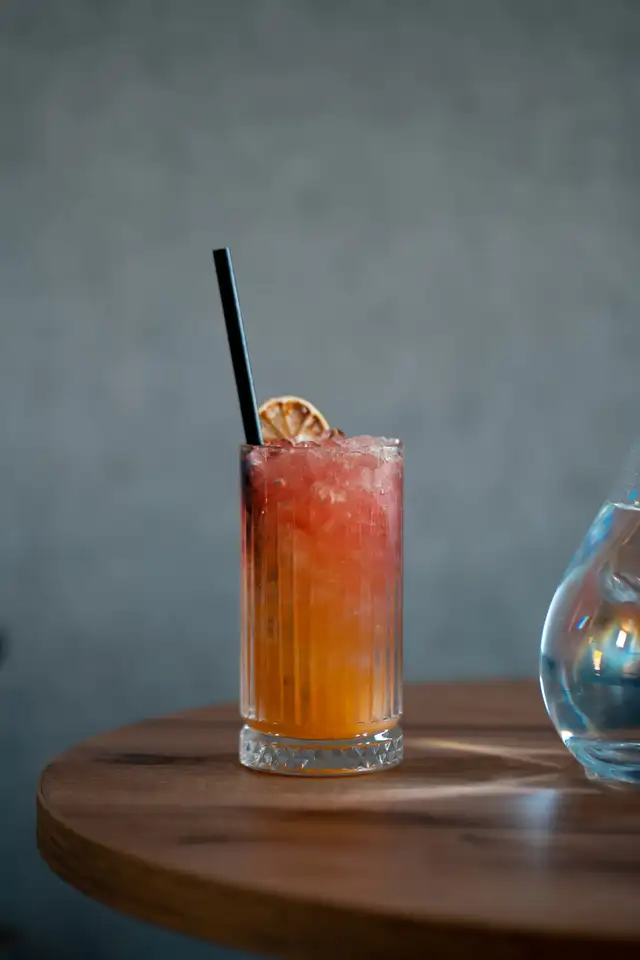 Cocktail sans alcool orangé dans un grand verre sur une table en bois