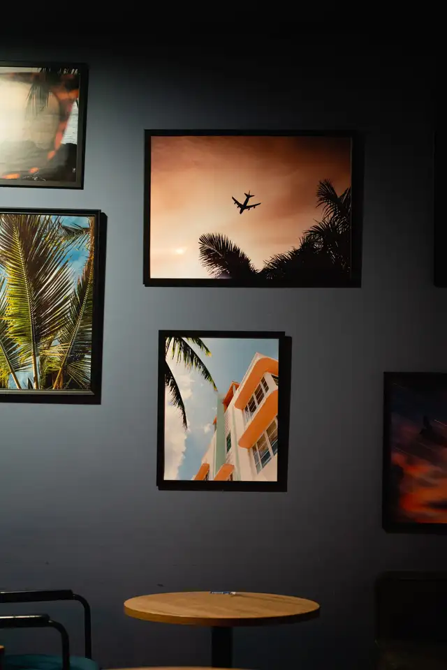 Cadres photo tropicaux accrochés sur un mur gris-bleu
