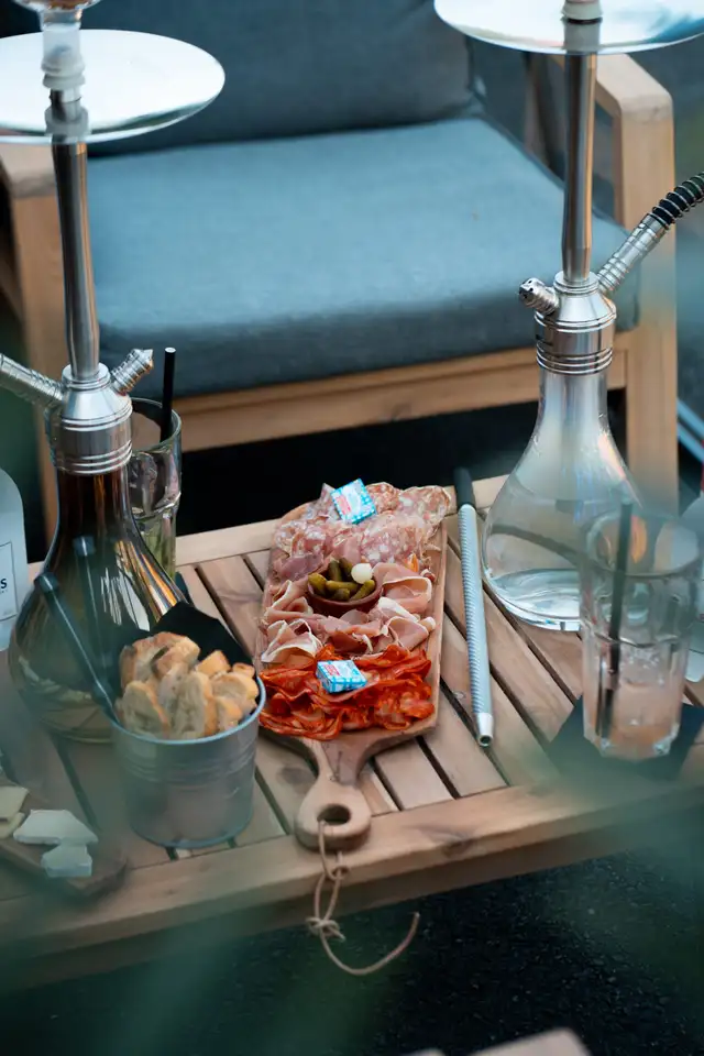 Planche à partager et tuyaux de narguilé sur une table en bois