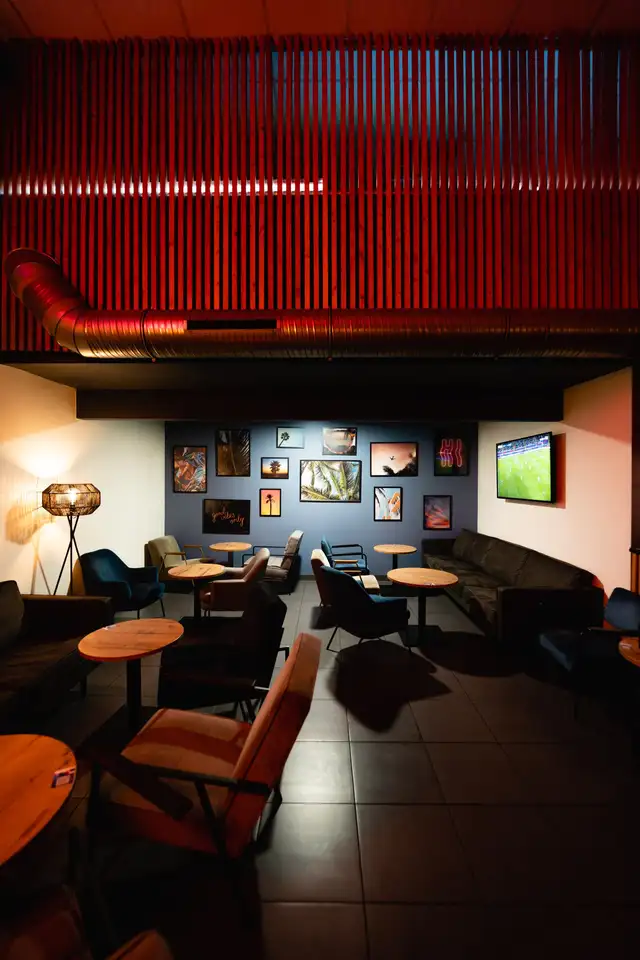 Coin salon devant un écran de télévision, mur à lattes rouges